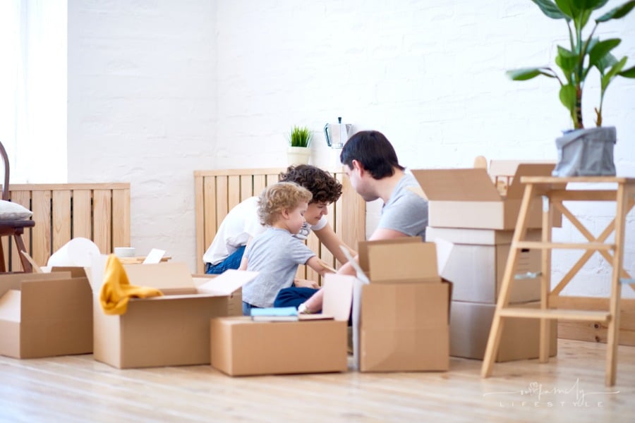 mother, father, and son unpacking boxes in new apartment