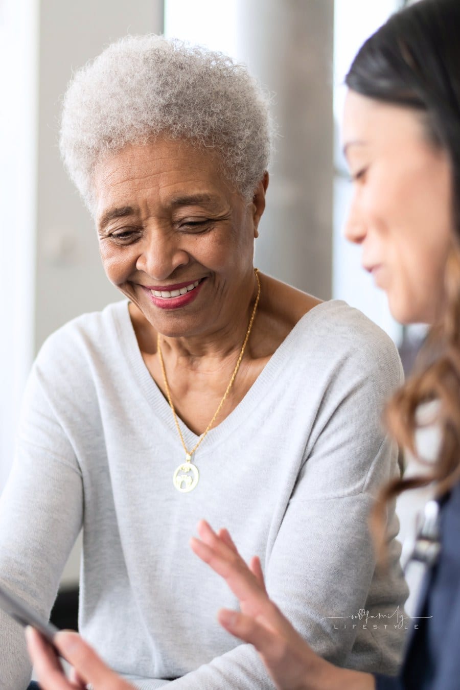 Young doctor holding a tablet while explaining care elderly patient