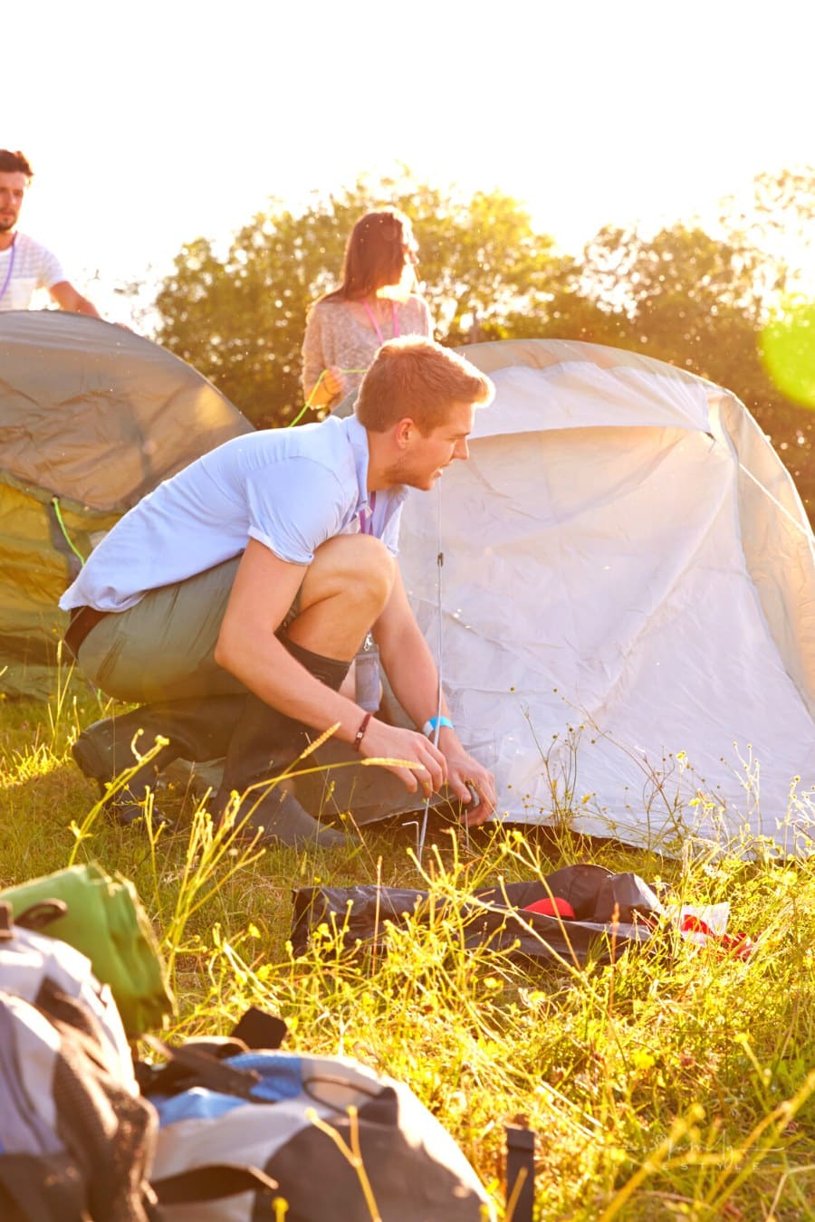 friends pitching tents for camping trip