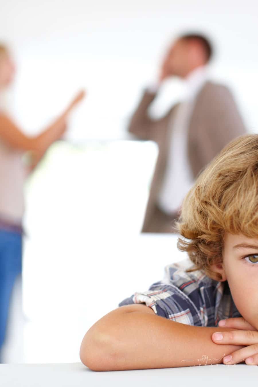 sad boy listening to paernts arguing in the background