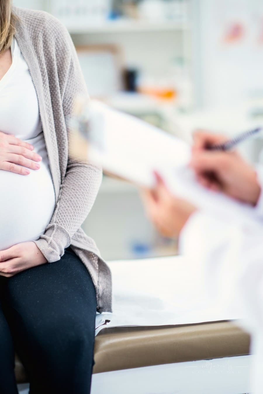pregnant patient sitting on exam table talking to ob/gyn