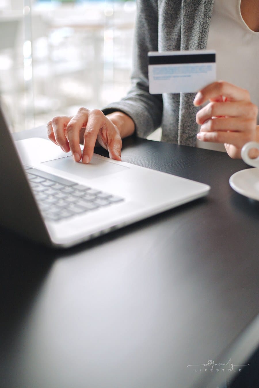 woman holding credit card while shopping online