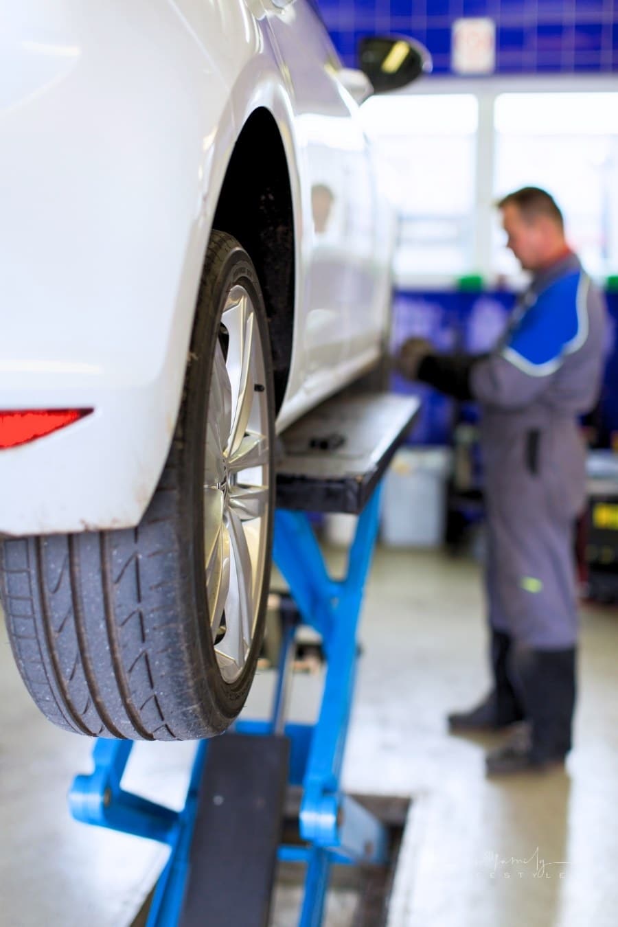 mechanic rotating tires on a car