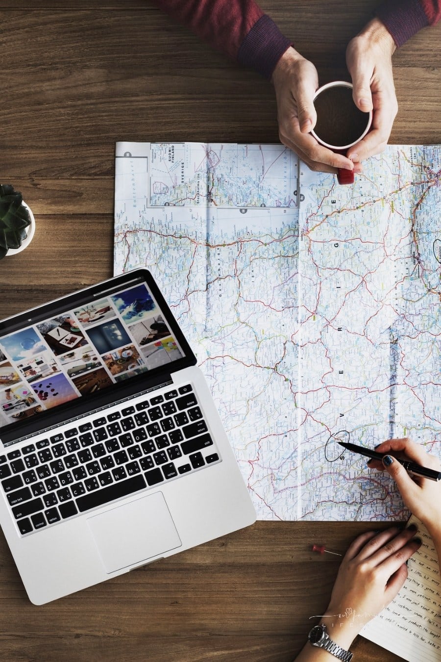 couple planning vacation with laptop and map