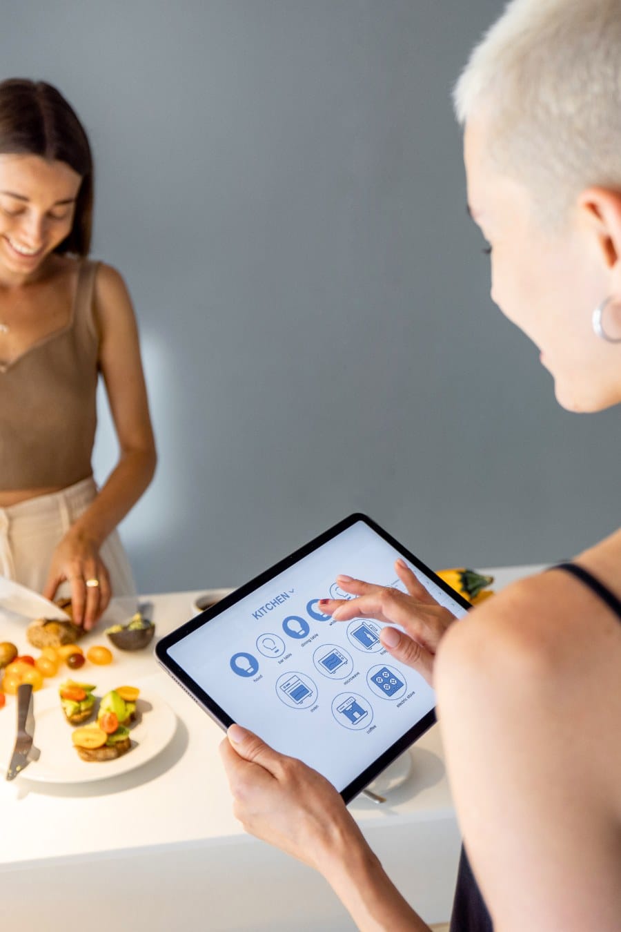 Woman Controls Smart Kitchen Appliances with Smart Tablet