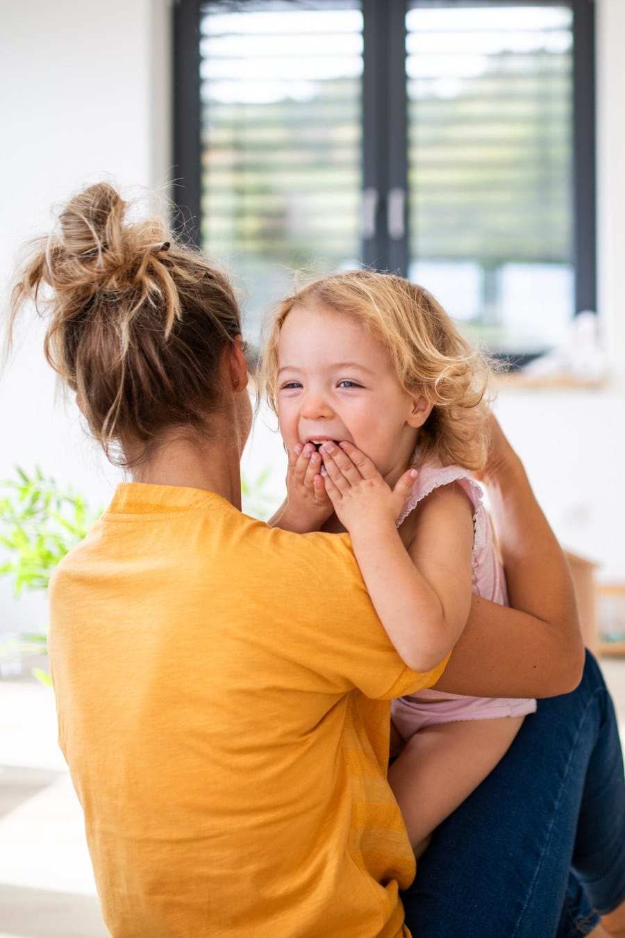 Young Mom with Small Children in Bedroom Having Fun