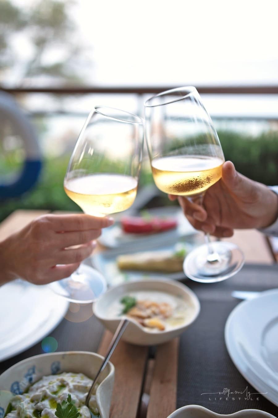 romantic dinner table with two hands toasting champagne