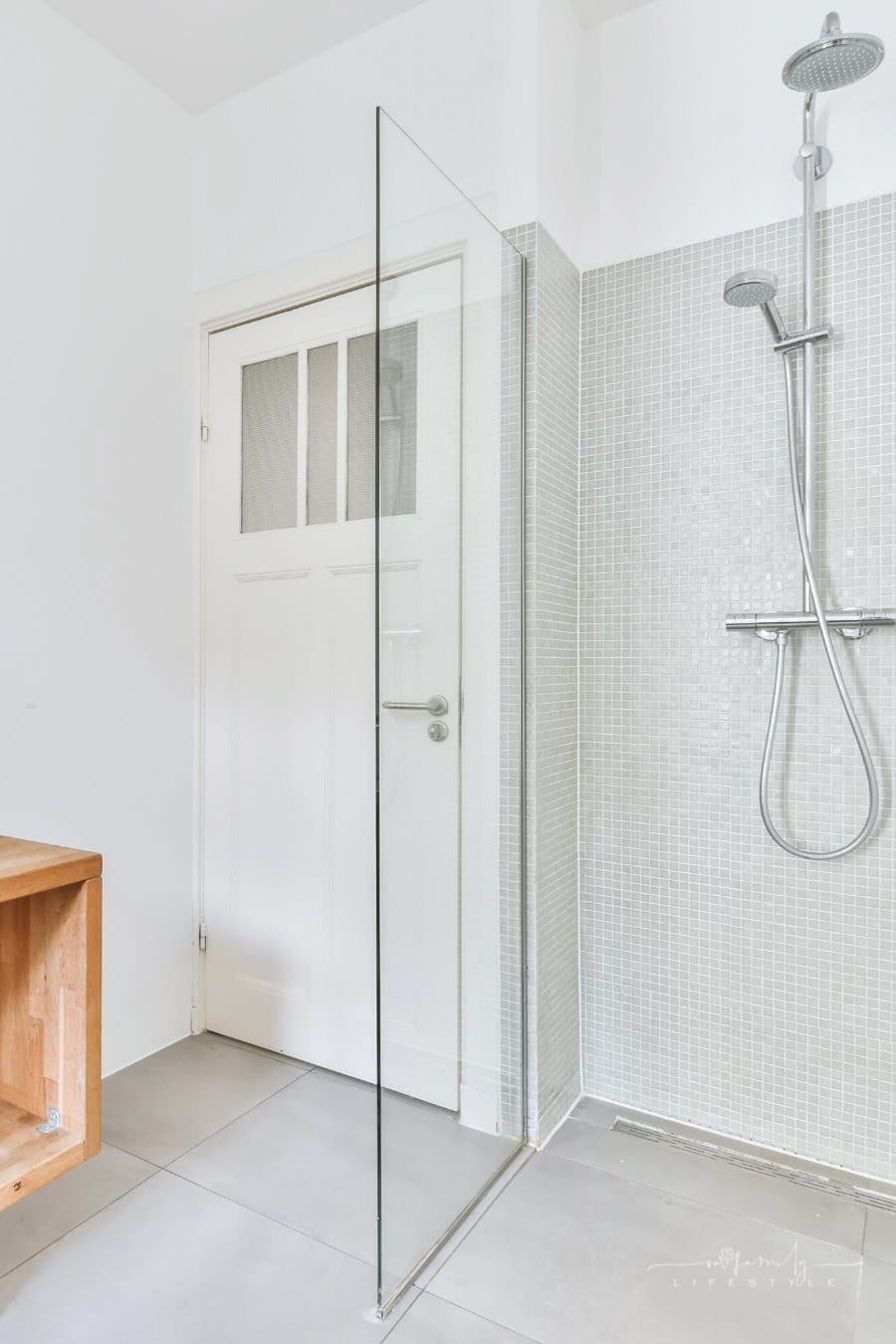 modern shower stall with grey tile and two rain shower heads