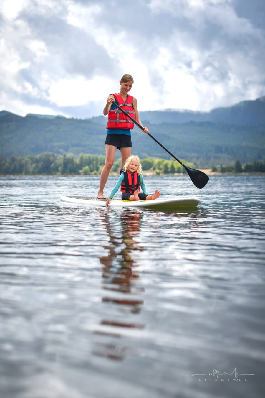 mother and young daughter stand-up paddle boarding