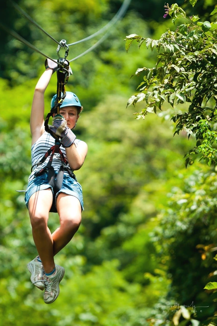 young girl ziplining on aerial steel cable