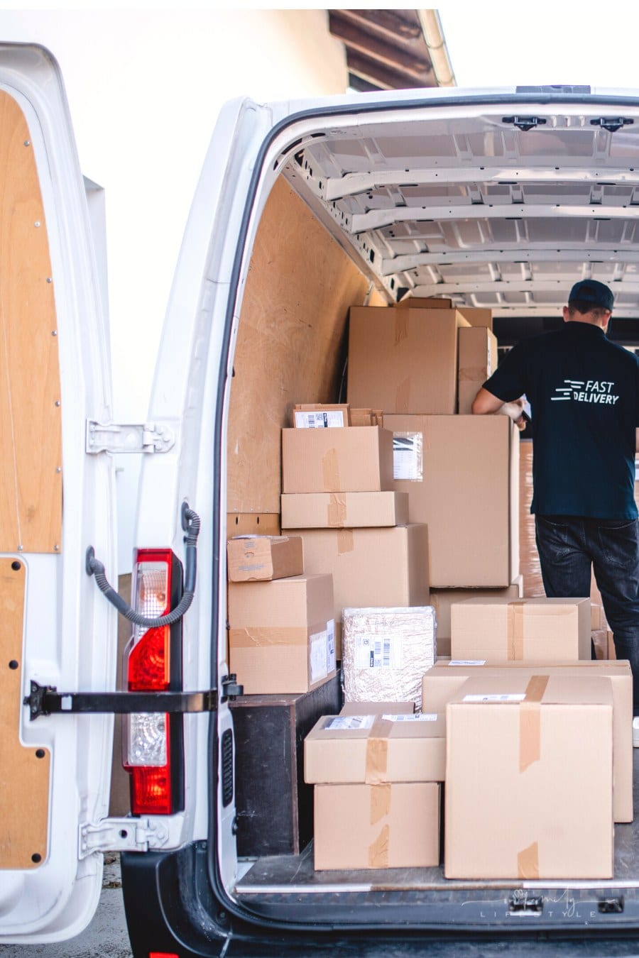 male driver inside delivery van full of packages