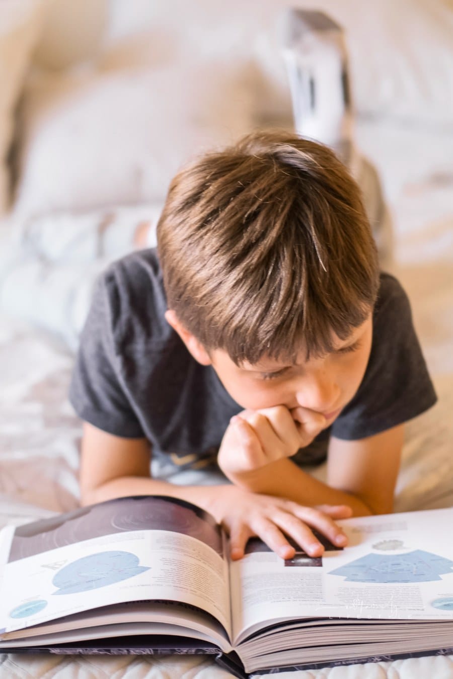 A Boy Reading a Book with feet up behind him