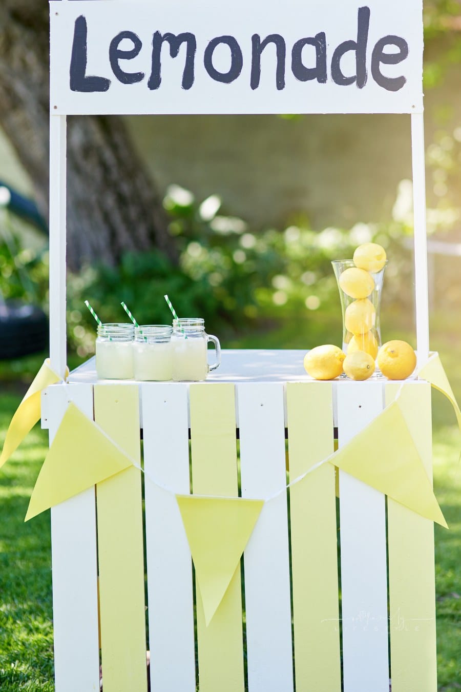 white wooden lemonade stand in front yard