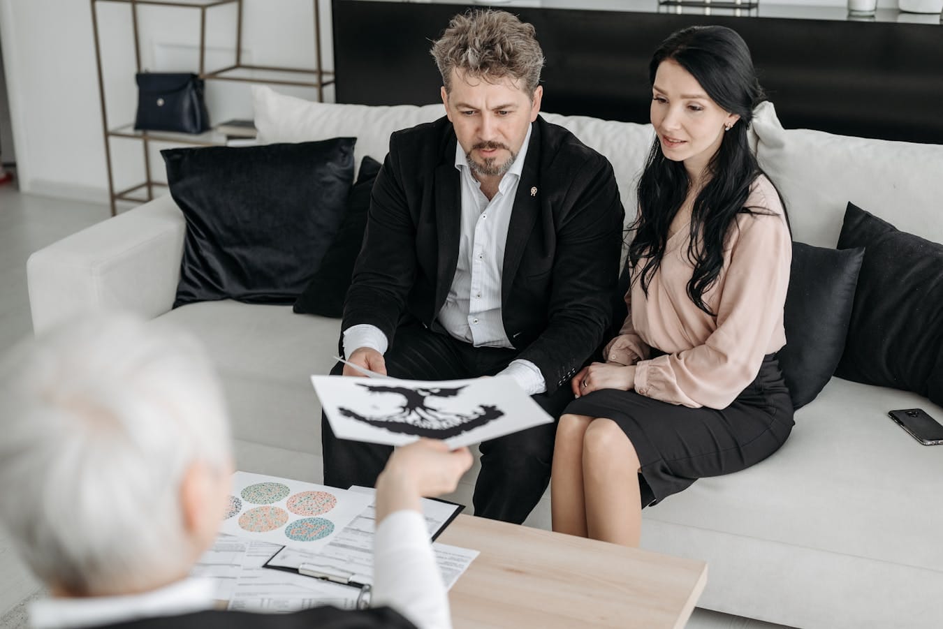 A foster couple consulting with a professional advisor indoors, focused on documents.