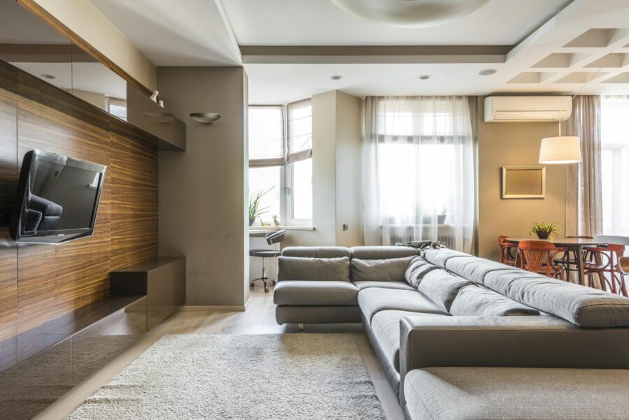 A cozy and modern living room with a large sofa and natural lighting.