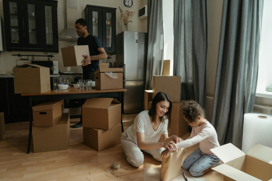 A family unpacks boxes in their new apartment kitchen, symbolizing a fresh start.