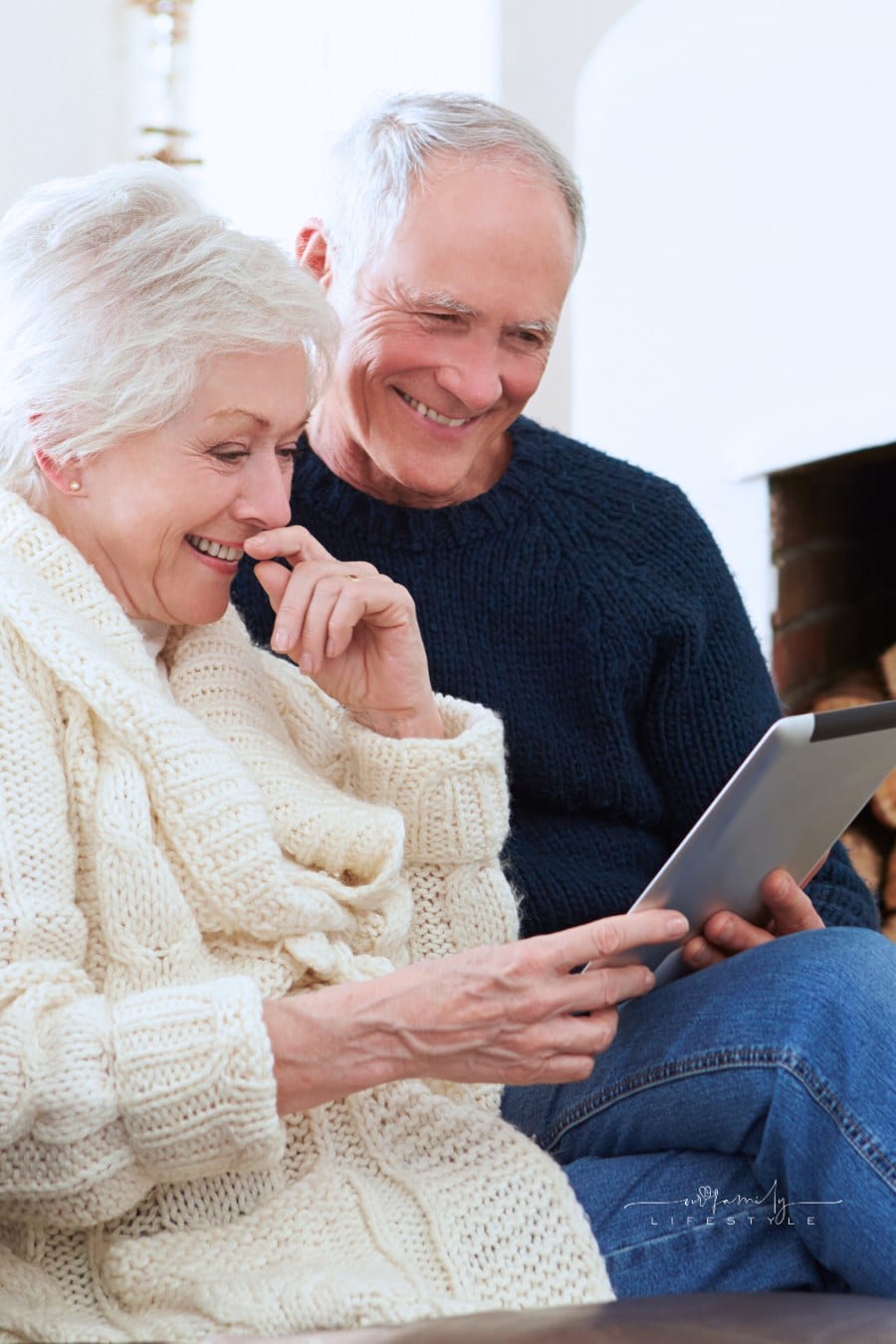 Senior Couple Using Digital Tablet While Sitting on Sofa