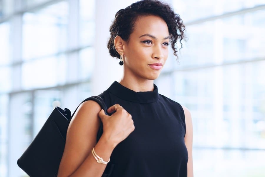 confident young businesswoman walking through a modern office