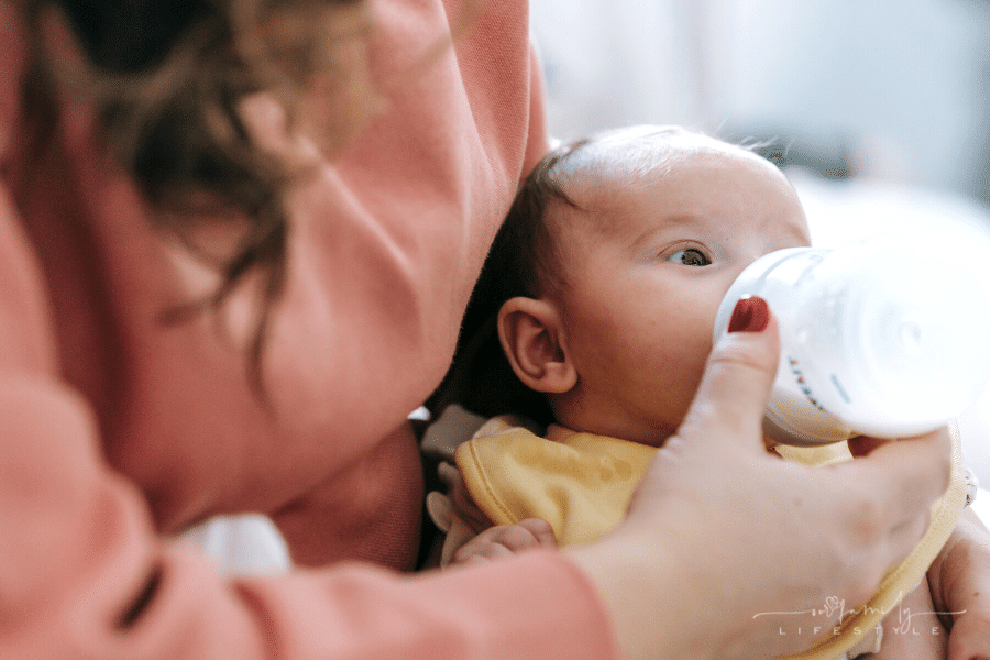 mom feeding baby a bottle in her arms