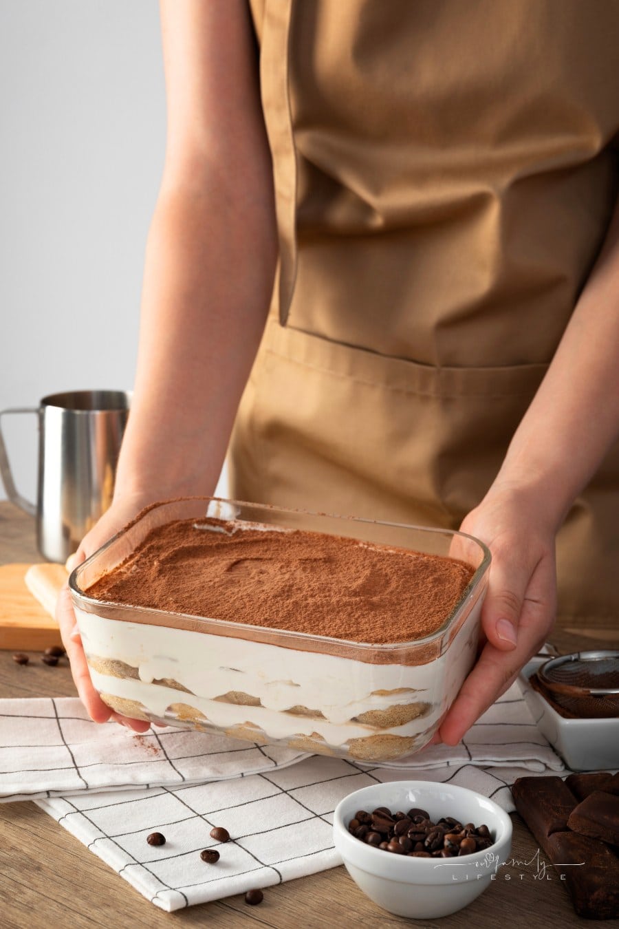 chef holding out finished tiramisu ready to serve