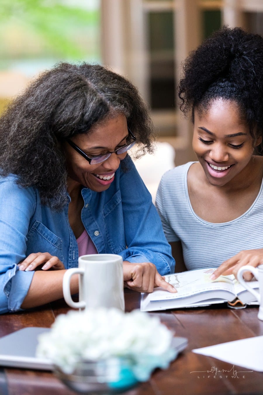 mom helps daughter college student with reading homework in a textbook