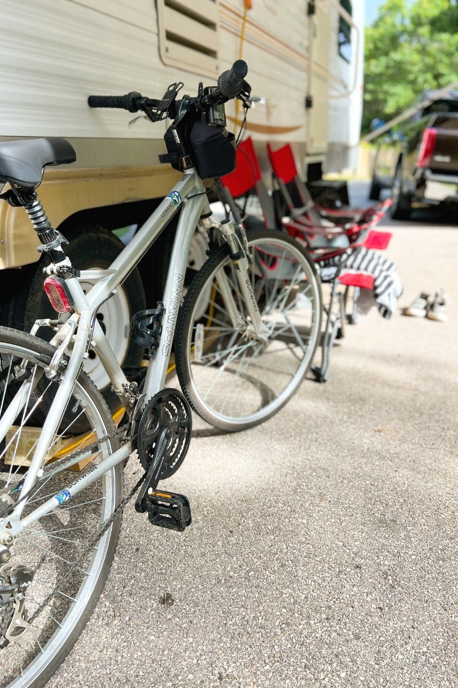 bikes and camping chairs outside of an RV travel trailer door