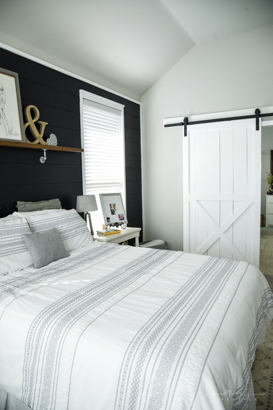 black accent wall and white barn door bedroom