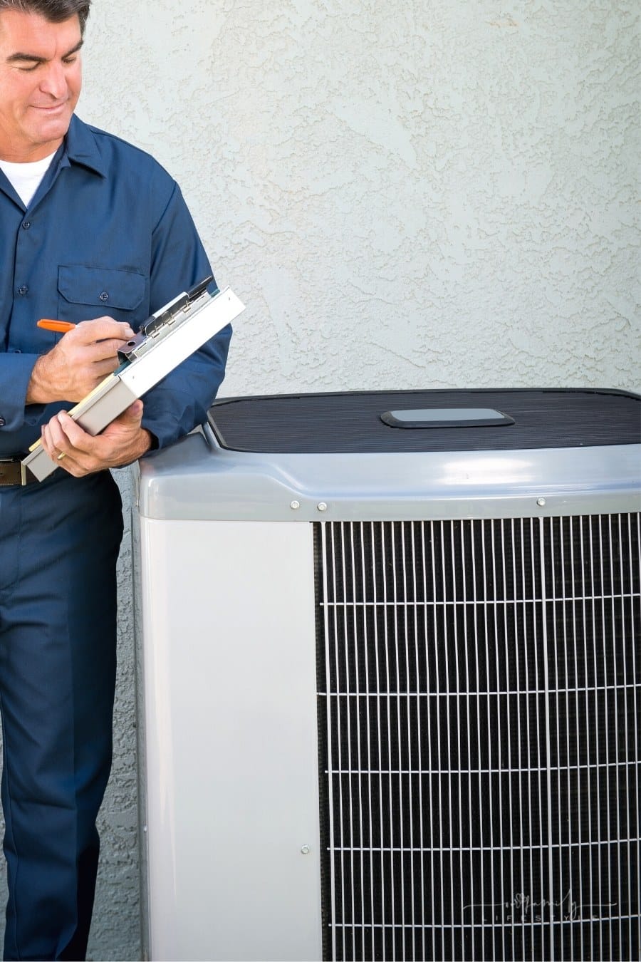 air conditioner repairman with clipboard by outside unit