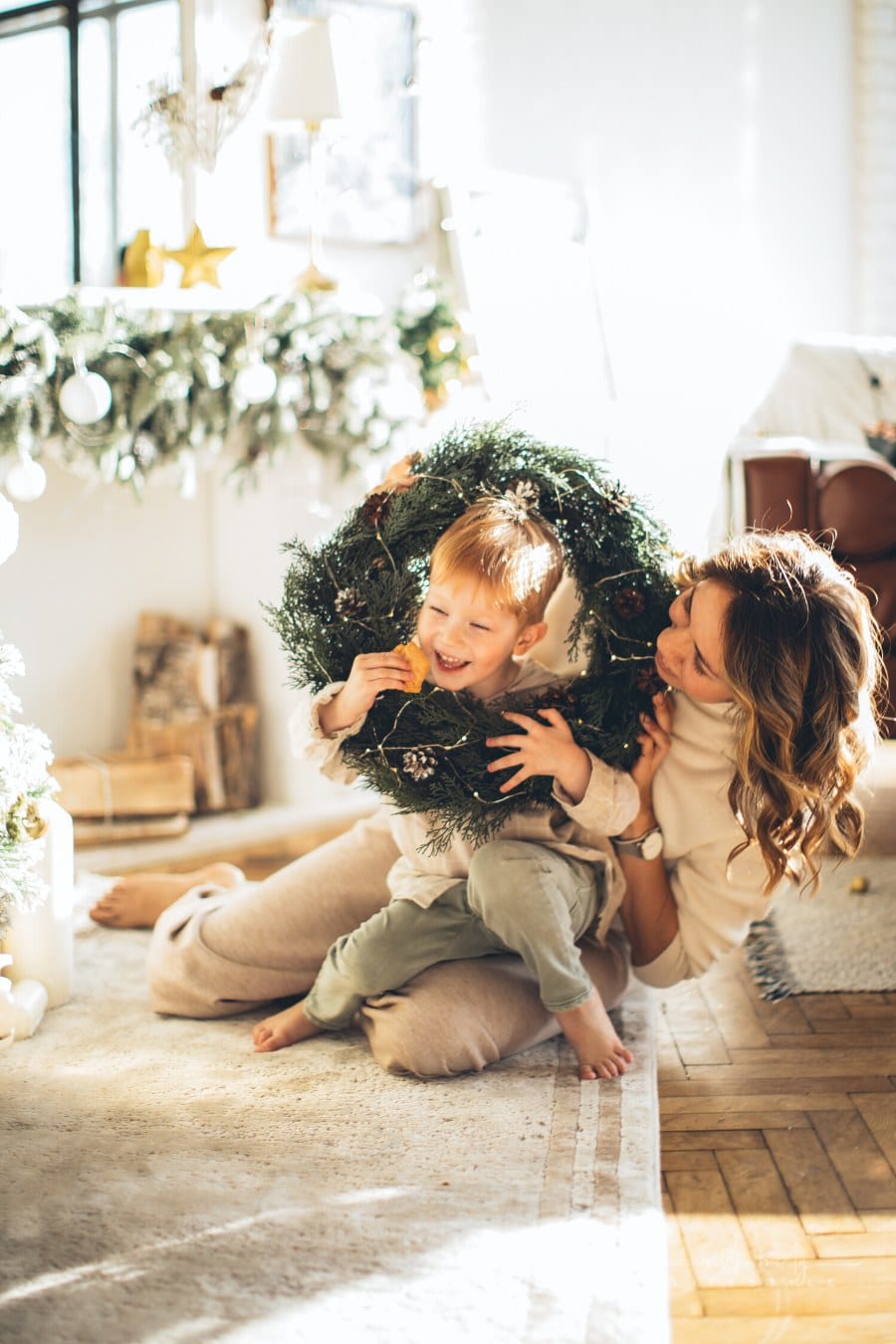 mother and child playing with a Christmas wreath