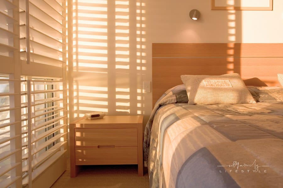 beautiful golden light filtering though bedroom shutters