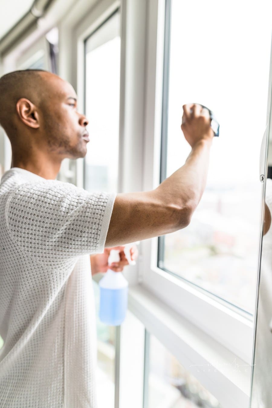 man cleaning the windows of his house