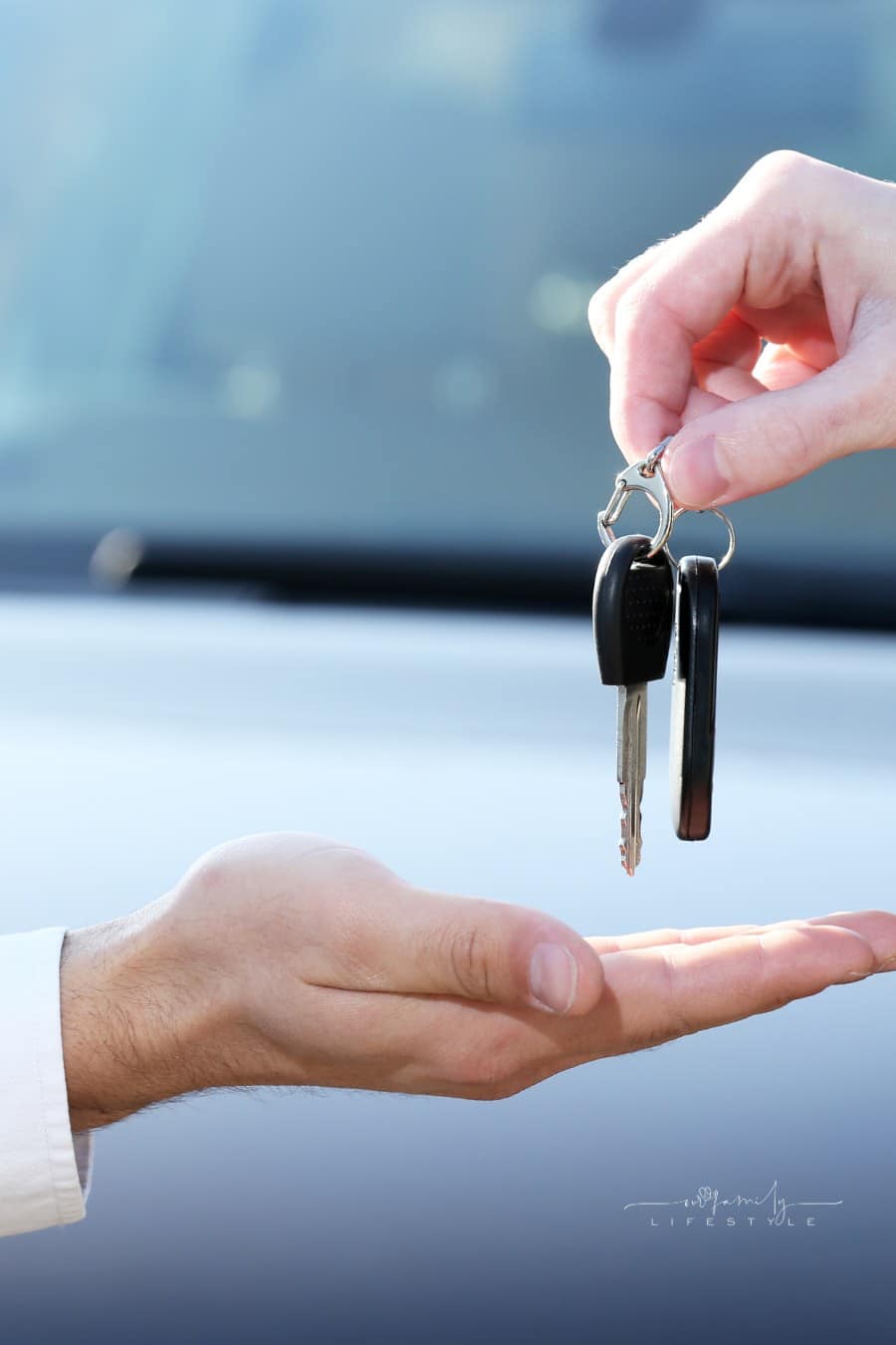 salesman handing keys to car buyer