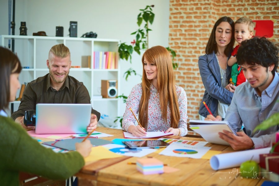 family business working on financials with child looking on