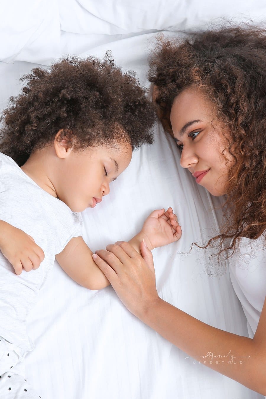 Mother with Sleeping Daughter Lying on Bed