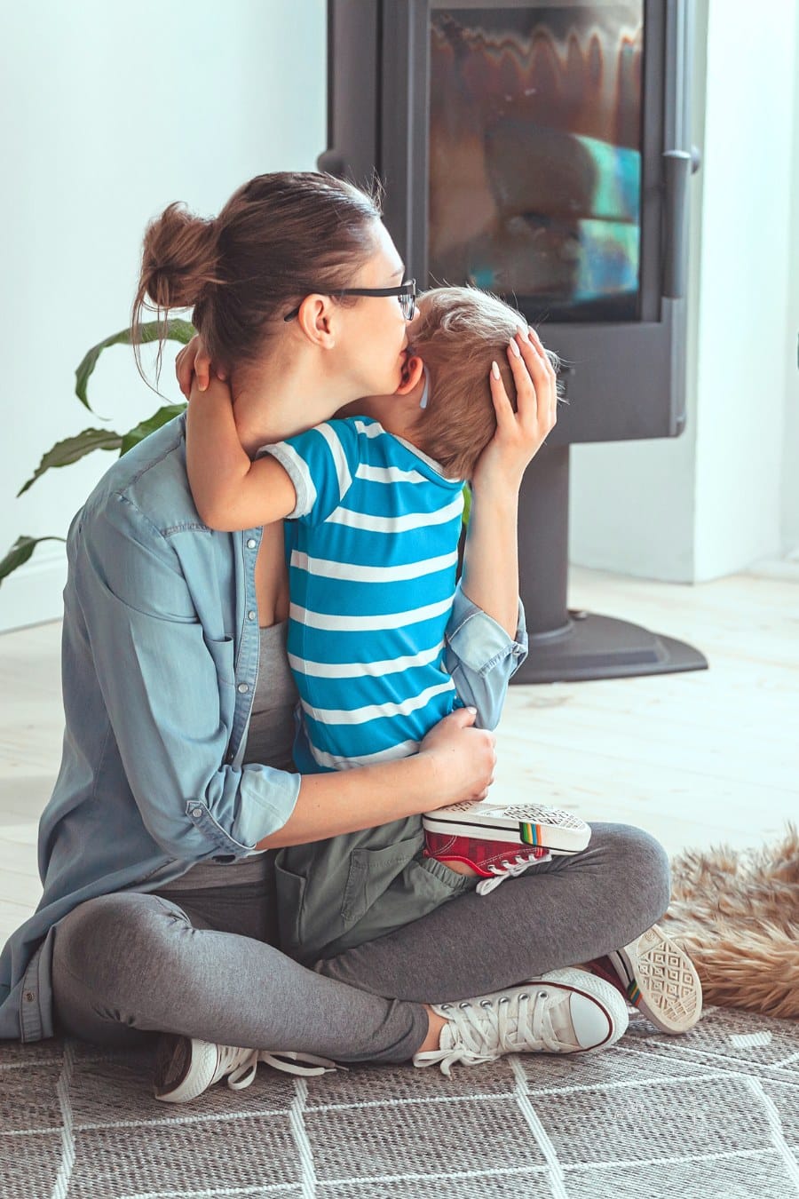 mom hugging son with autism while sitting on the floor