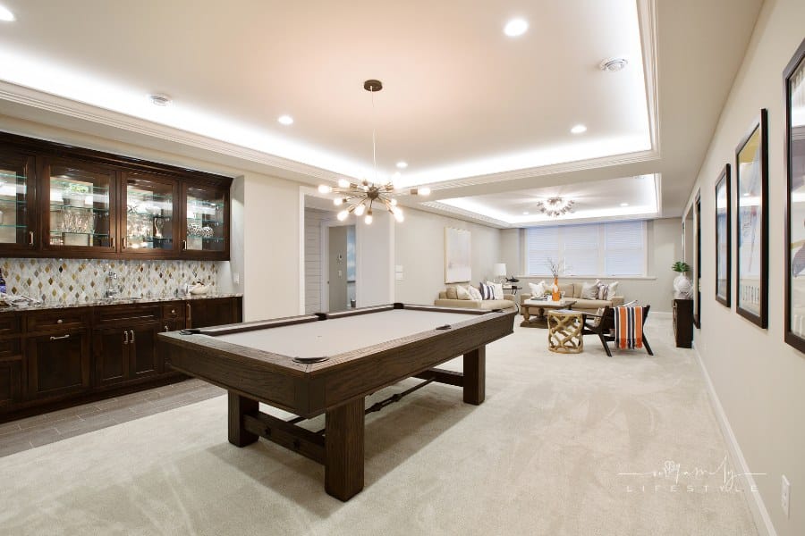 basement family room with LED lighting in tray ceiling, billiards table, and kitchenette