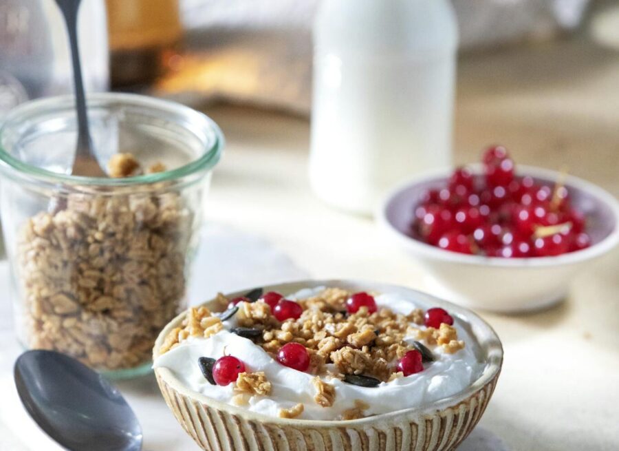 Delicious yogurt bowl topped with granola and red currants, perfect for a healthy breakfast.