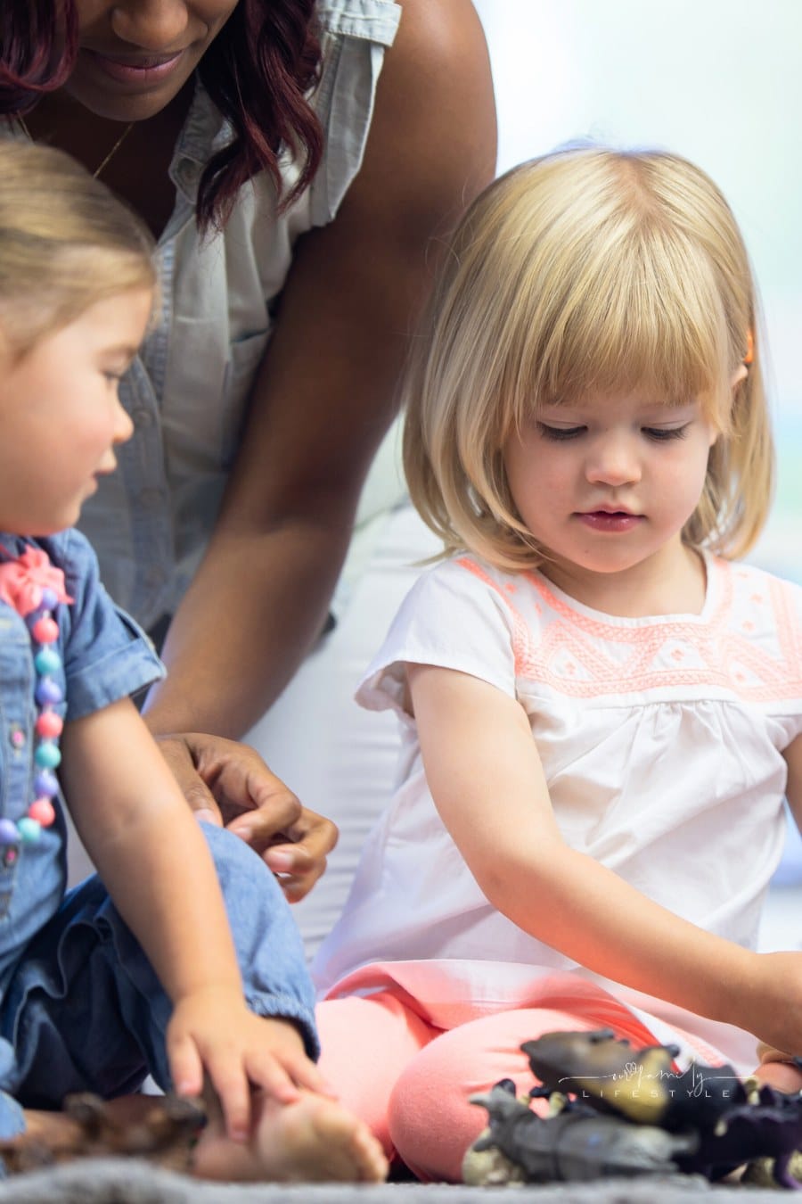 Daycare teacher builds blocks with toddlers