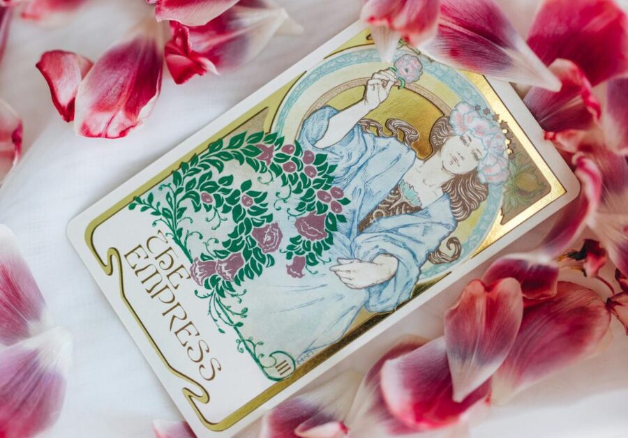 Elegant tarot card surrounded by vibrant pink petals, featuring a mystical feminine illustration, perfect for spiritual theme