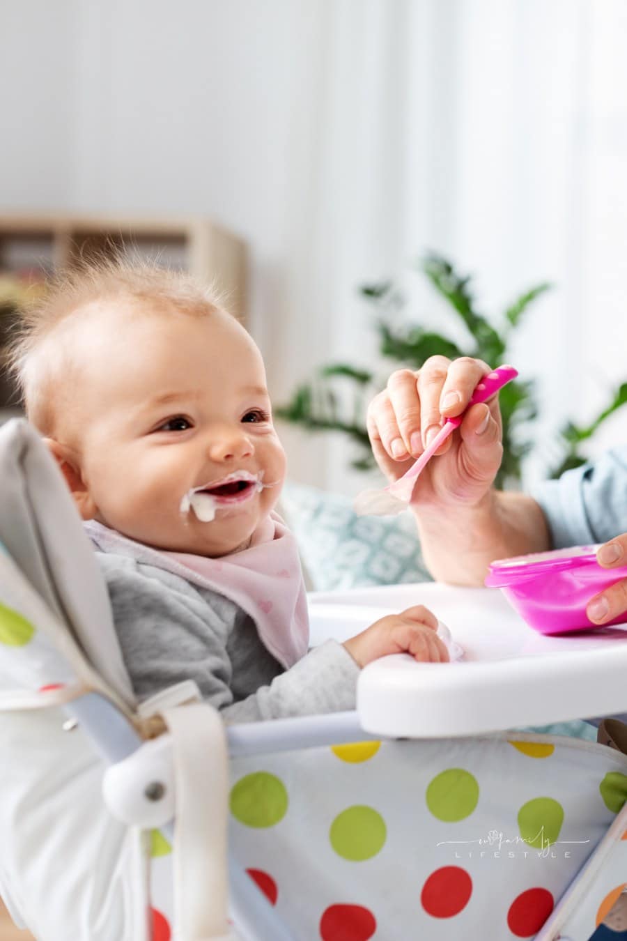 Father Feeding Baby in Highchair at Home