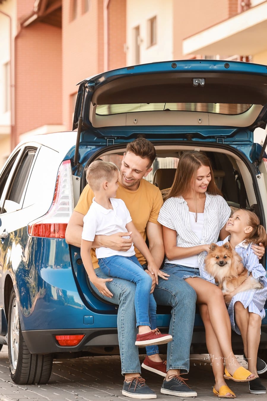 Happy Family sitting in back of Car Outdoors