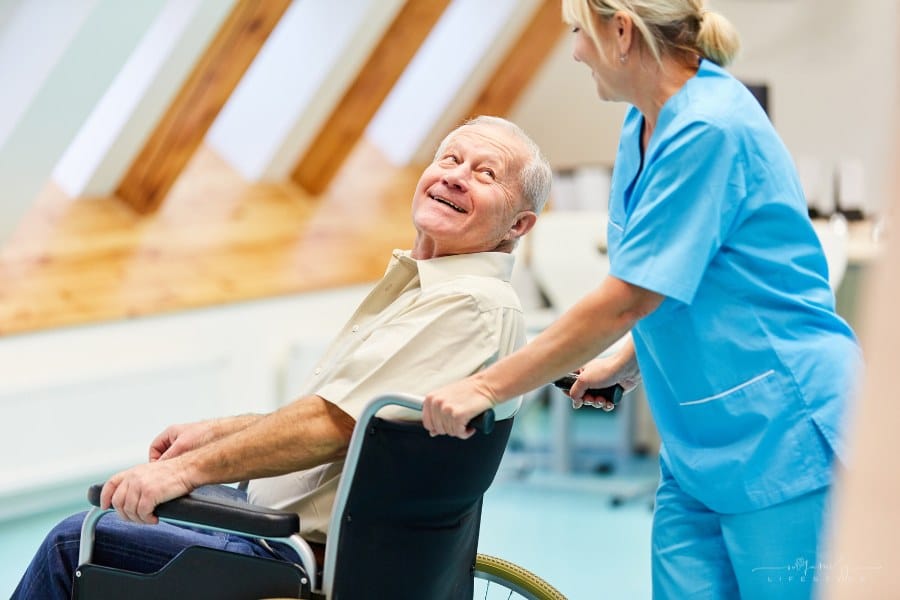 nurse pushing senior man in wheelchair