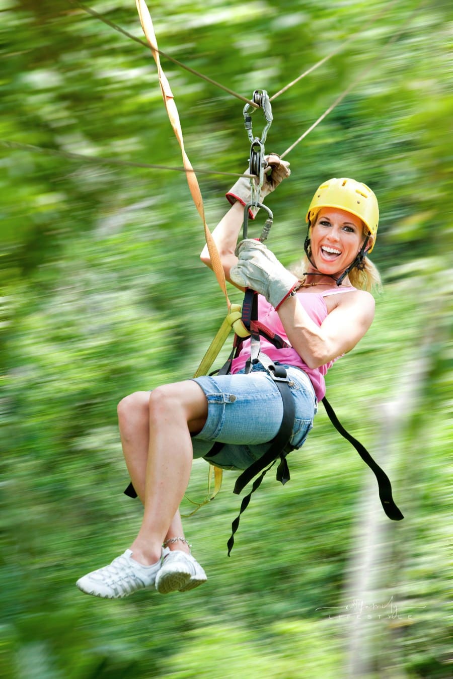 Excited woman on zipline in motion blur