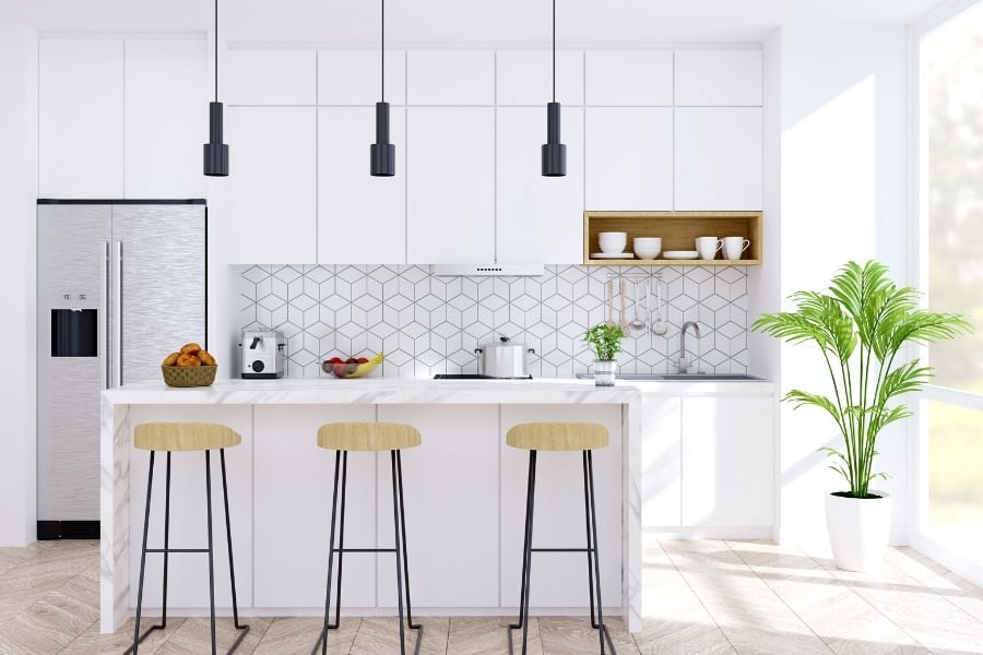modern kitchen with stools at marble counter and black pendants overhead