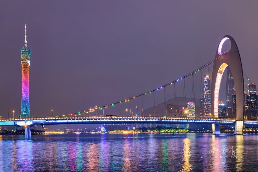 Guangzhou cityscape skyline with Canton Tower over the Pearl River illuminated in the evening panorama. Guangzhou, China.