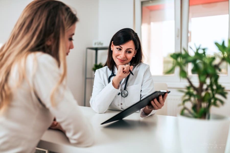 patient looking at papers doctor is showing her over a desk