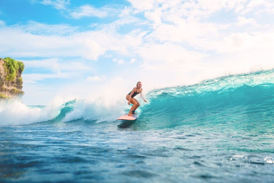 Surfer woman on surfboard during surfing. Surfer and ocean wave