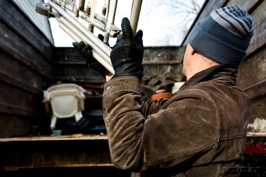 man throwing junk into back of truck