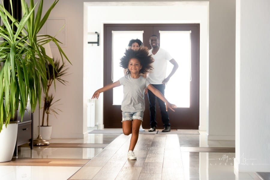 Small happy girl run in hallway moving into new house