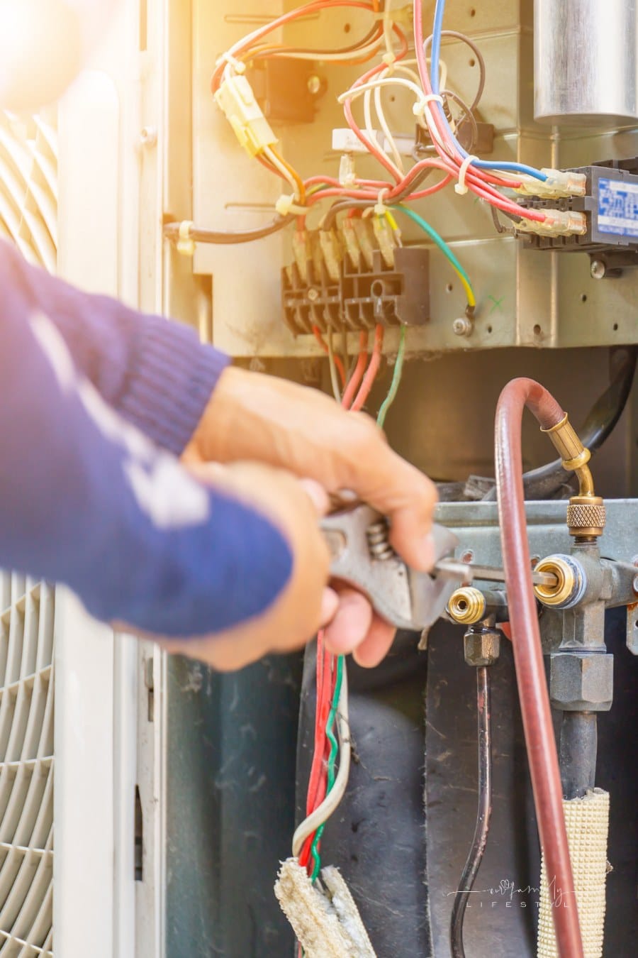 close up of hands repairing an air conditioner unit